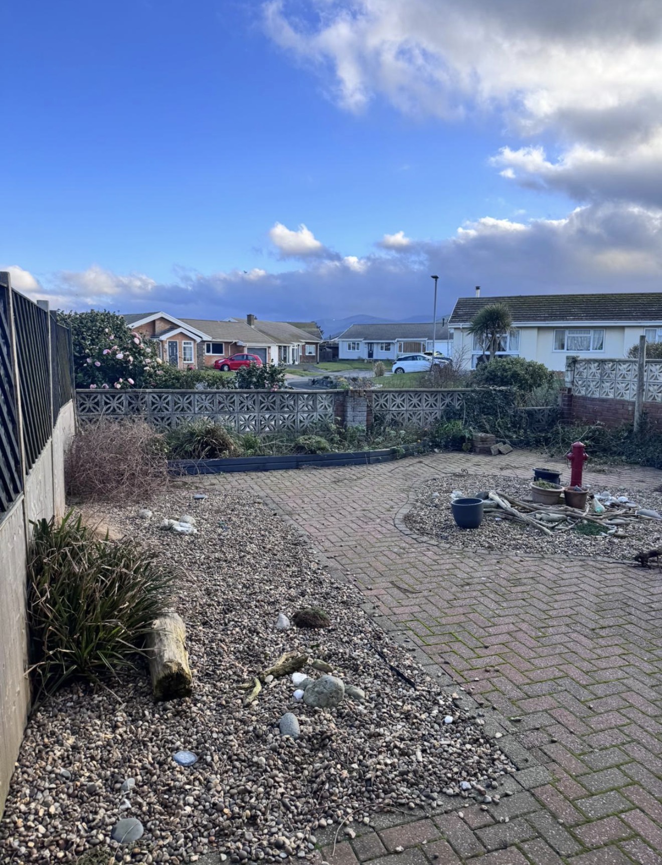 Garden boundary before clearance with old timber fencing and gravel areas